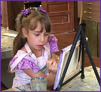 Maia painting at an easel