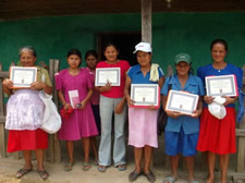 Women health volunteers display certificates after completion of domestic violence training.