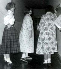 Students, Diane Blixt, Barb Mitchell and Gwen Houssian, in line to use the dorm telephone