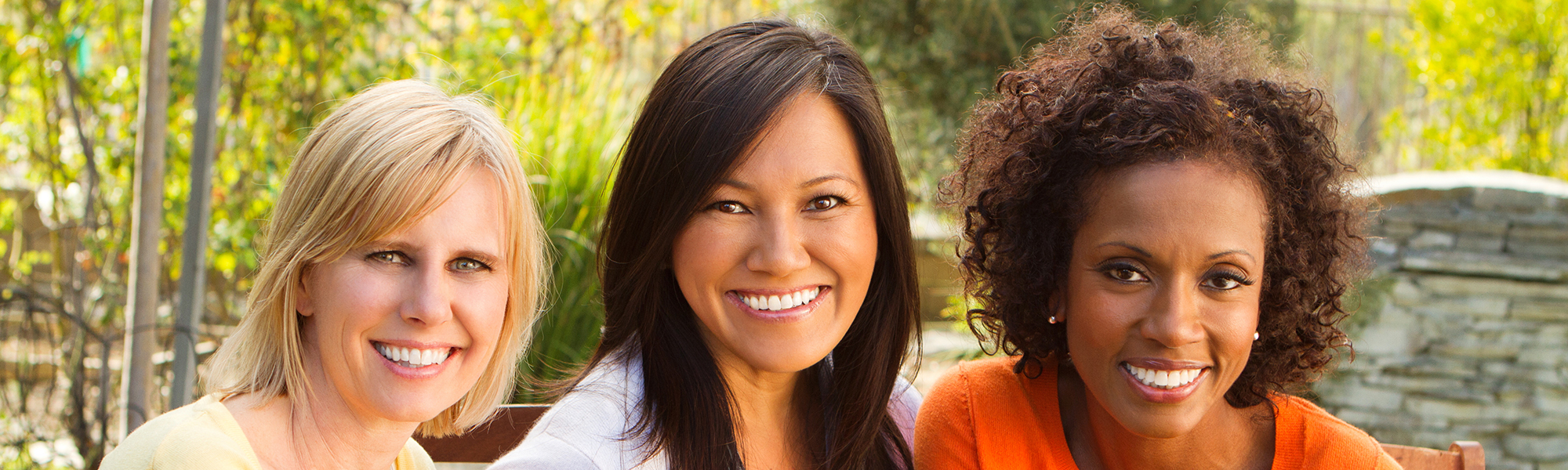 Group of three smiling women outdoors
