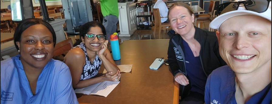 Dr. Deina Bossa, Dr. Snigdha Alur-Gupta, Dr. Kathryn Voss, and Dr. AJ Knutson sit together at a table