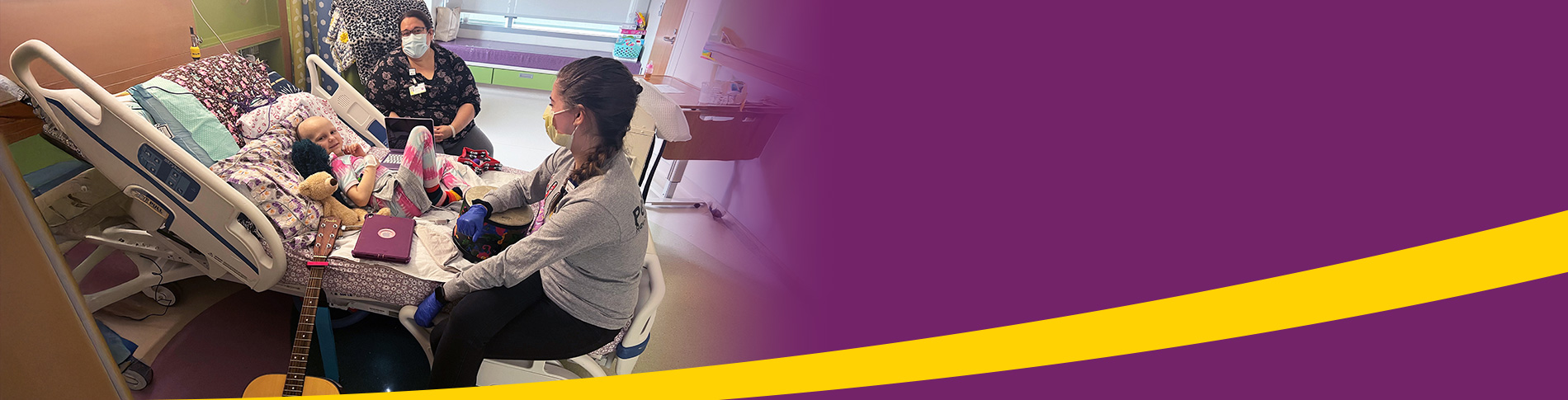 Image of Providers Next to Child with a Guitar Next to Her Hospital Bed