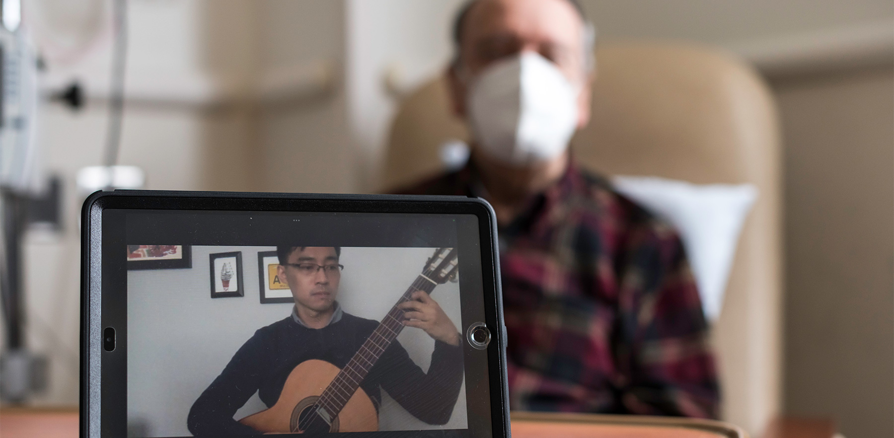 Man playing music on phone while patient watches