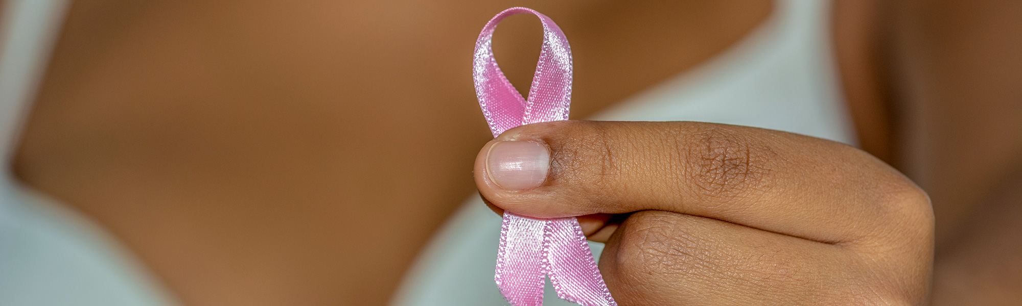 Woman holding out a breast cancer awareness ribbon