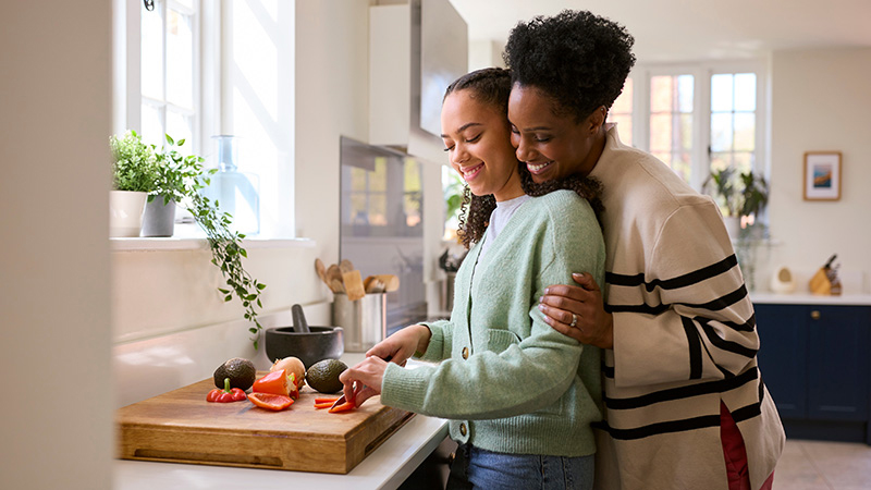 Mom hugging teen, both smiling
