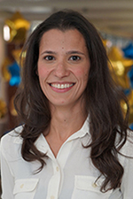 person with long hair in white blouse smiling at camera