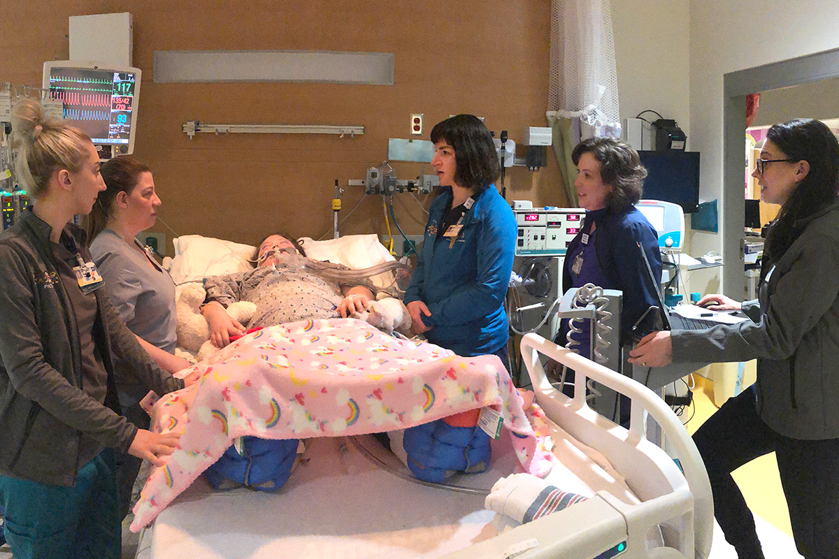 Healthcare team, including Mom at child's bedside.