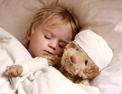 Child in bed with teddy bear