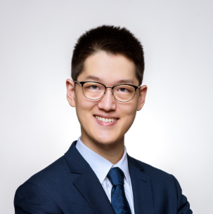 Person with glasses wearing suit and smiling at camera