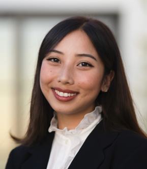 Person wearing white blouse and black blazer smiling at camera