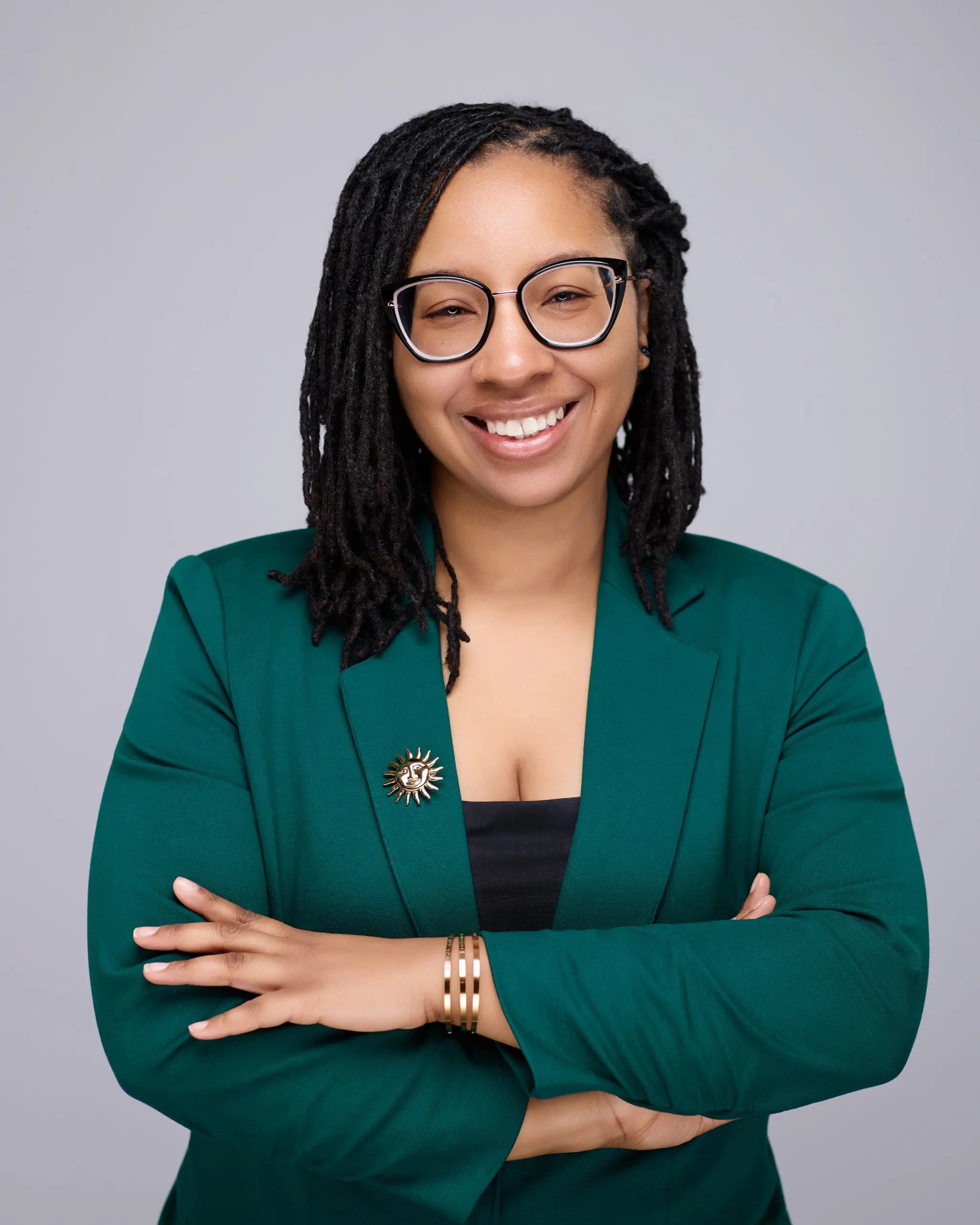 Person wearing glasses and suit smiling at camera