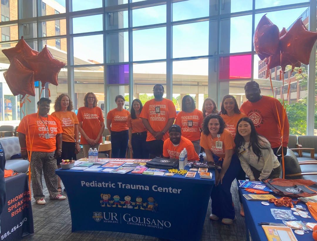 Group stands together at tabling event wearing orange in support of gun violence prevention