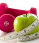 weights and apple wrapped in measuring tape