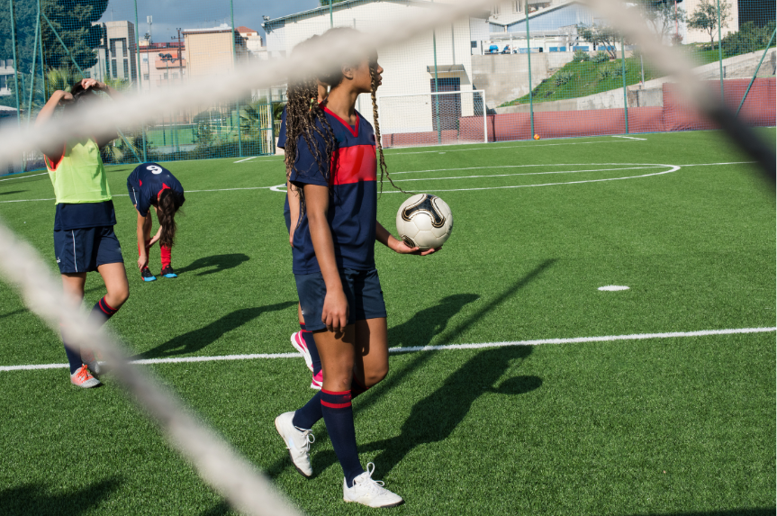 girls playing soccer on a turf