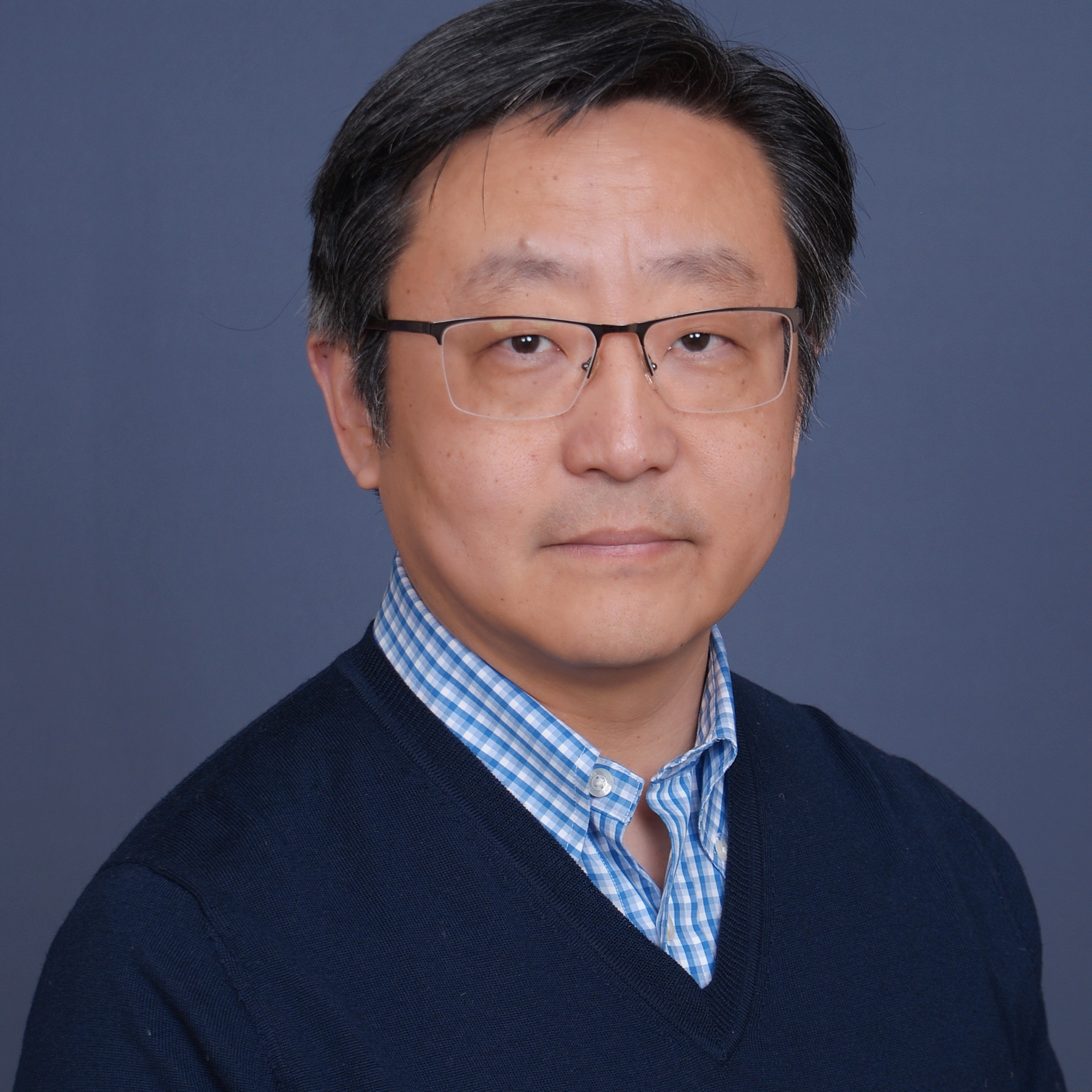 Jack Chang, man in thin glasses, dark hair, blue shirt, blue background