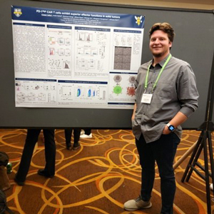 Photo of Cooper Sailer presenting a poster at a conference