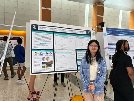 student next to scientific poster