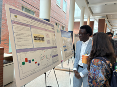 student presents scientific poster to group