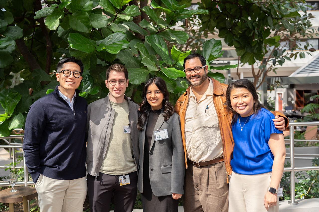 Five people standing together in front of a tree at the 2026 Handelman Conference.