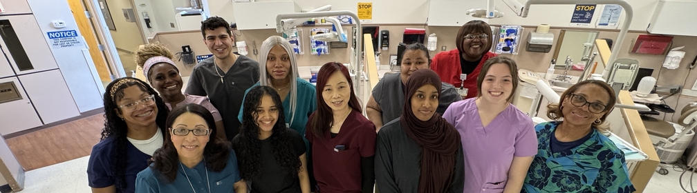 A large group of smiling dental assistants, representing a wide range of ages and ethnicities.