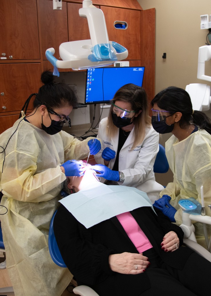 A dentist guides a resident in a procedure in the clinic.