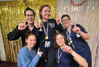 Residents holding up fingers indicating the number one wearing medals