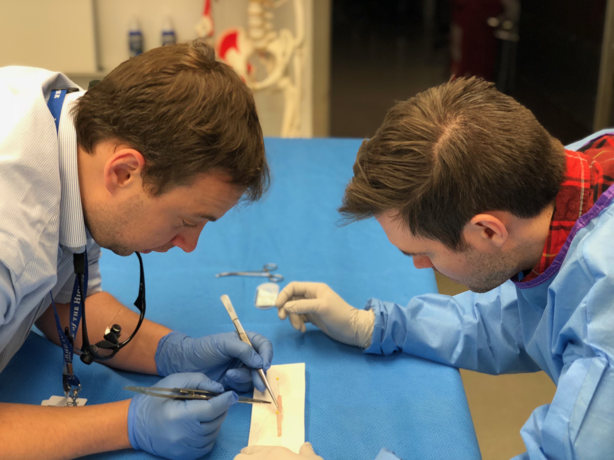 Two residents examine a vein