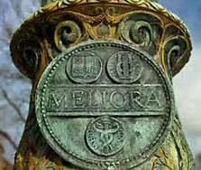 Meliora seal on post with blue sky behind