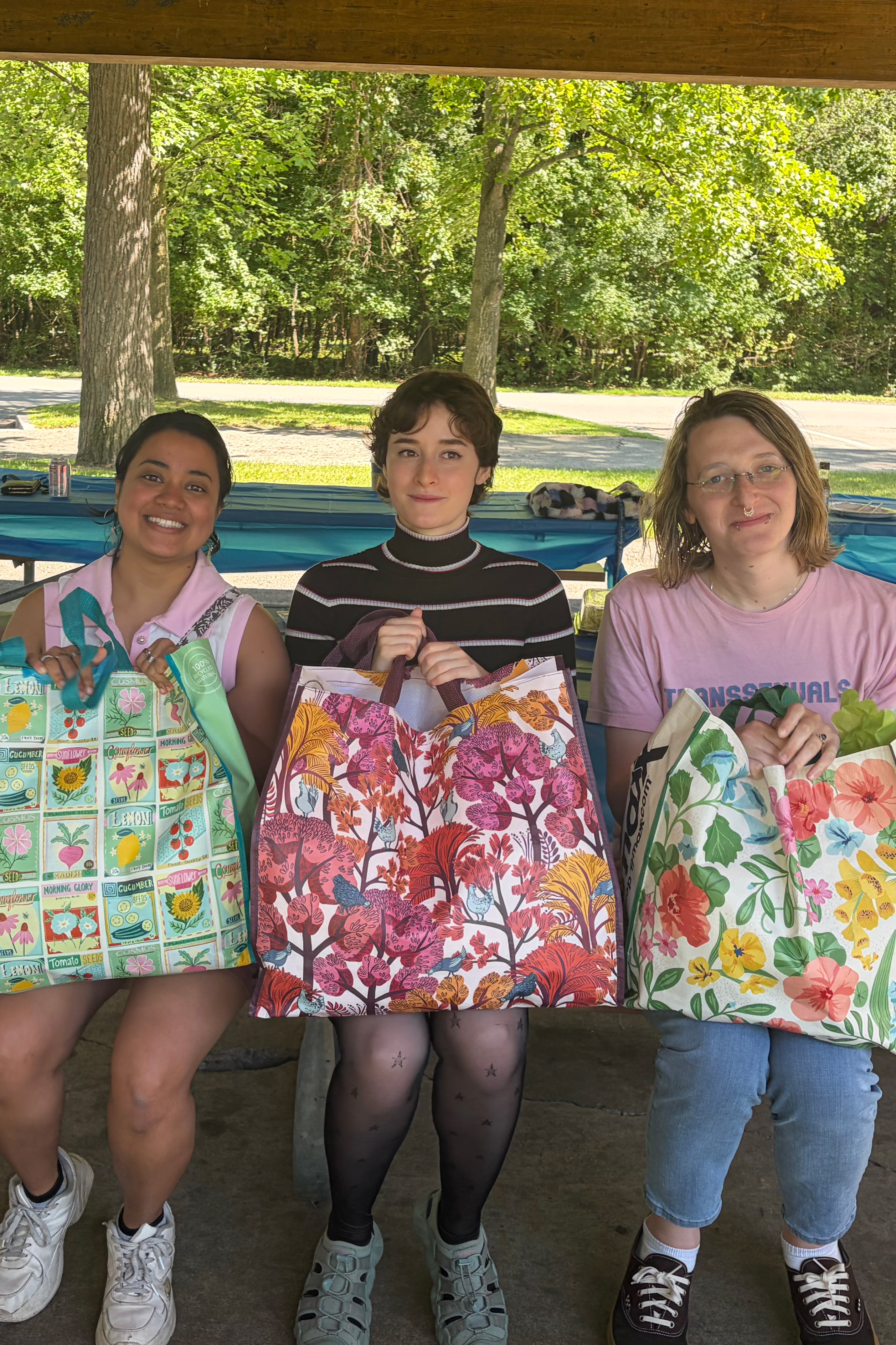 Student holding bags at a picnic table