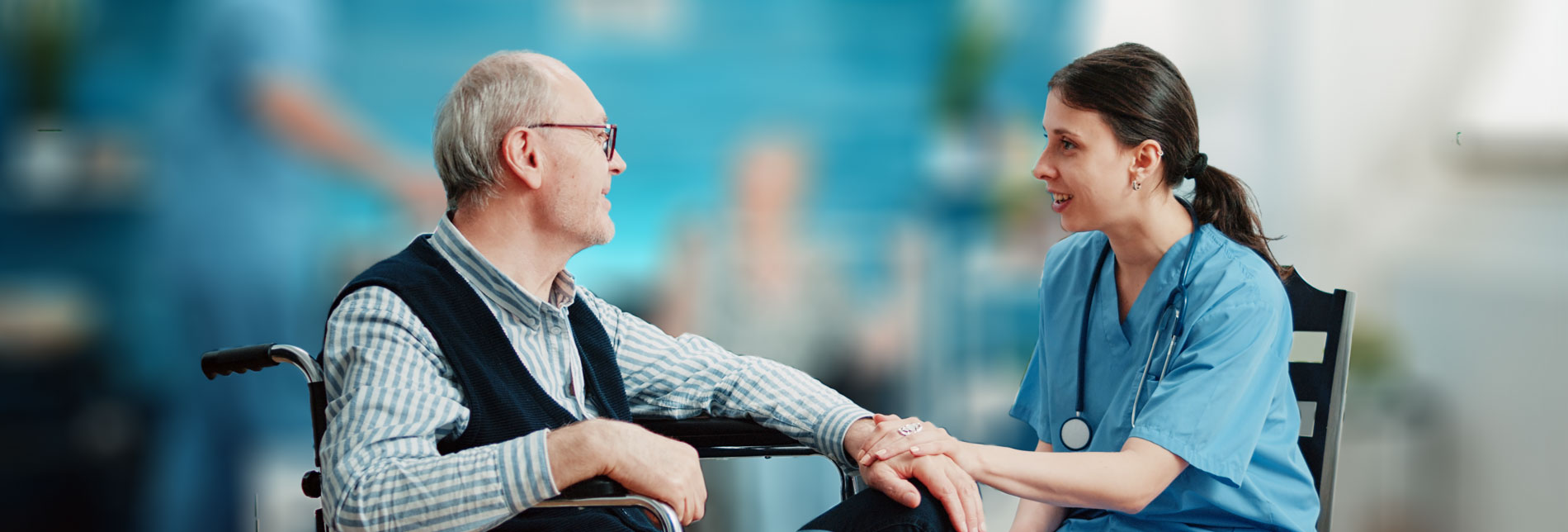 Nurse giving assistance to retired man in wheel chair