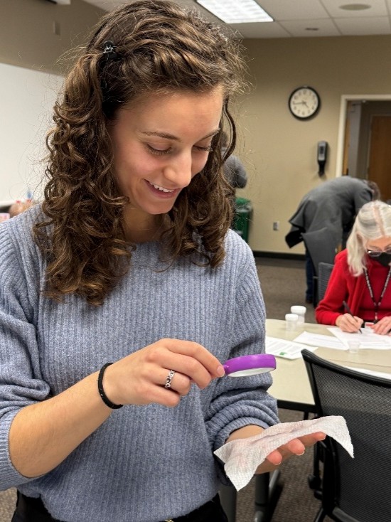 Participant looking through magnifying glass to a sample