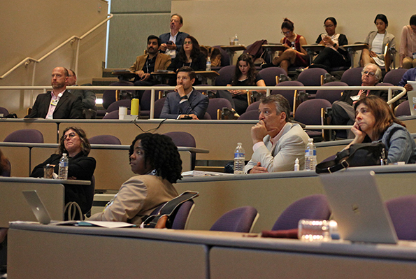 People in a room at a conference listening to a speaker