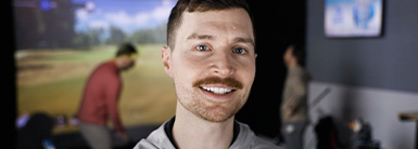 Male with brown hair smiling at the camera