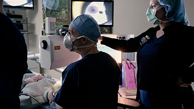 A female patient during a LASIK procedure with a doctor and nurse