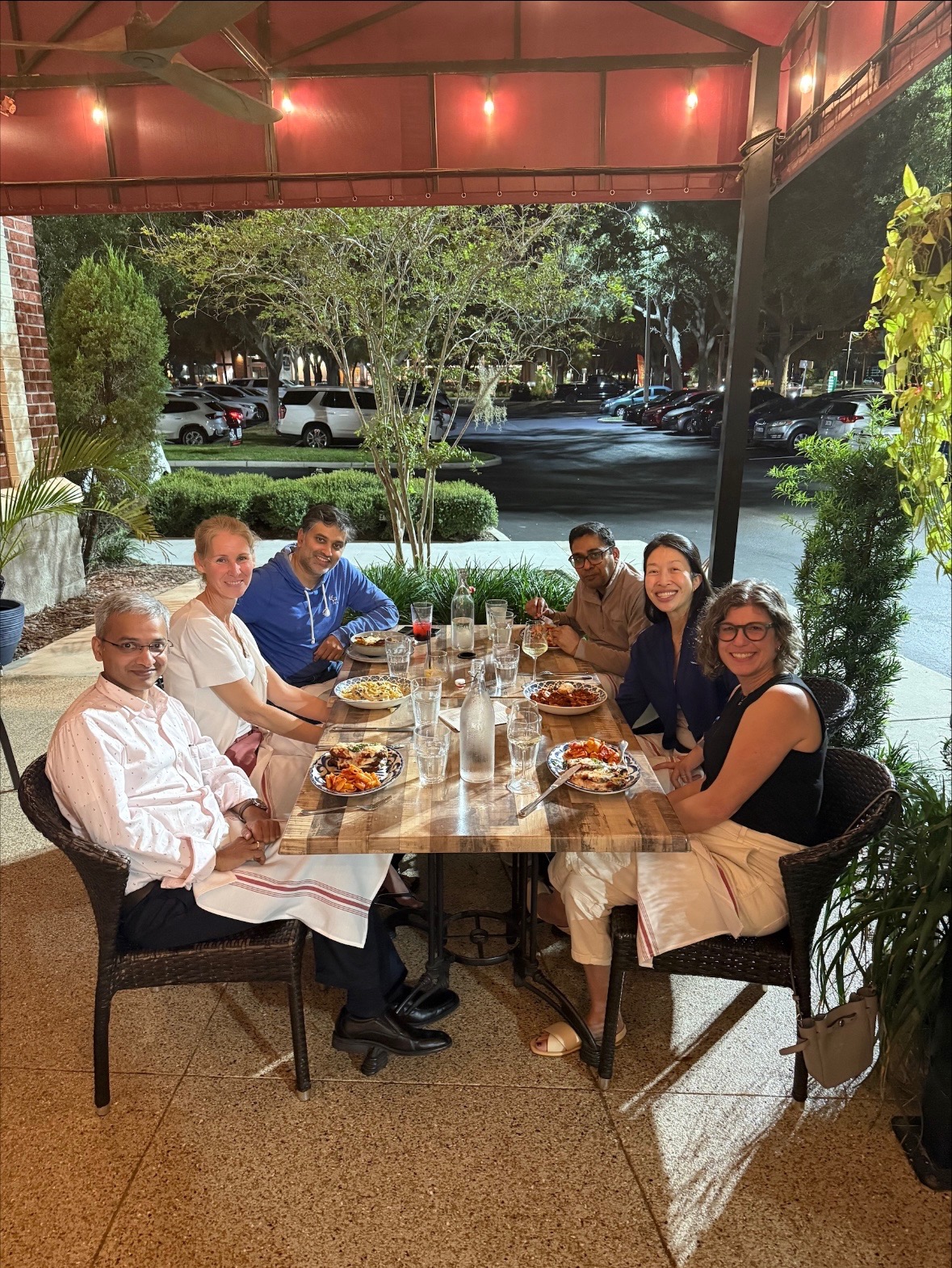 Flaum Eye Institute alumni gathering around a table at the reception following the AAO meeting.