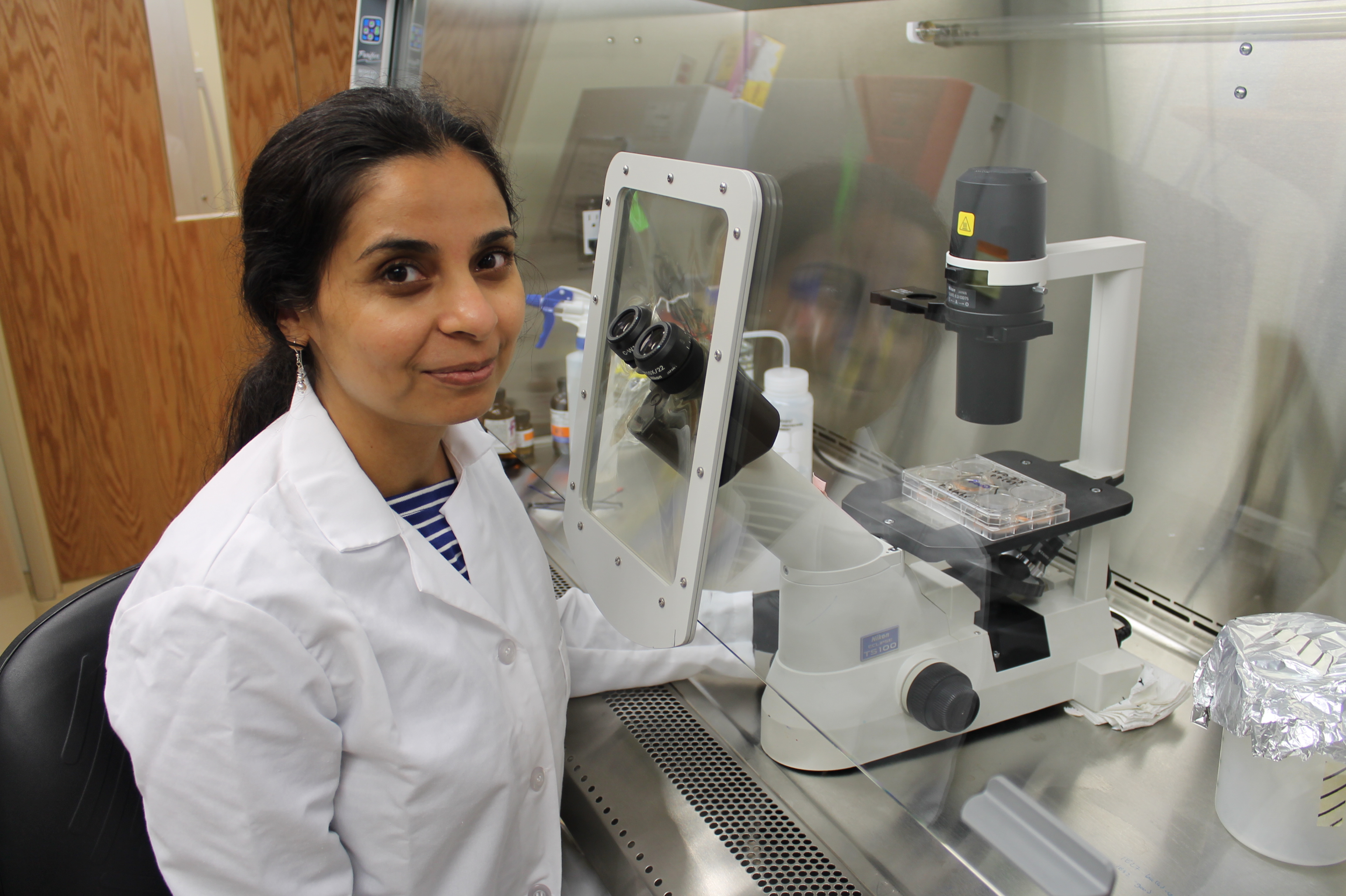 Dr. Singh in front of a microscope