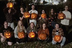 A group of residents holding carved pumpkins.