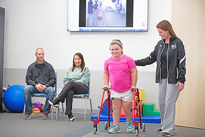 Young girl with a walker working with physical therapist.