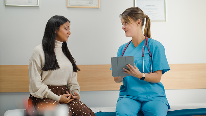 nurse talking with patient about information on ipad