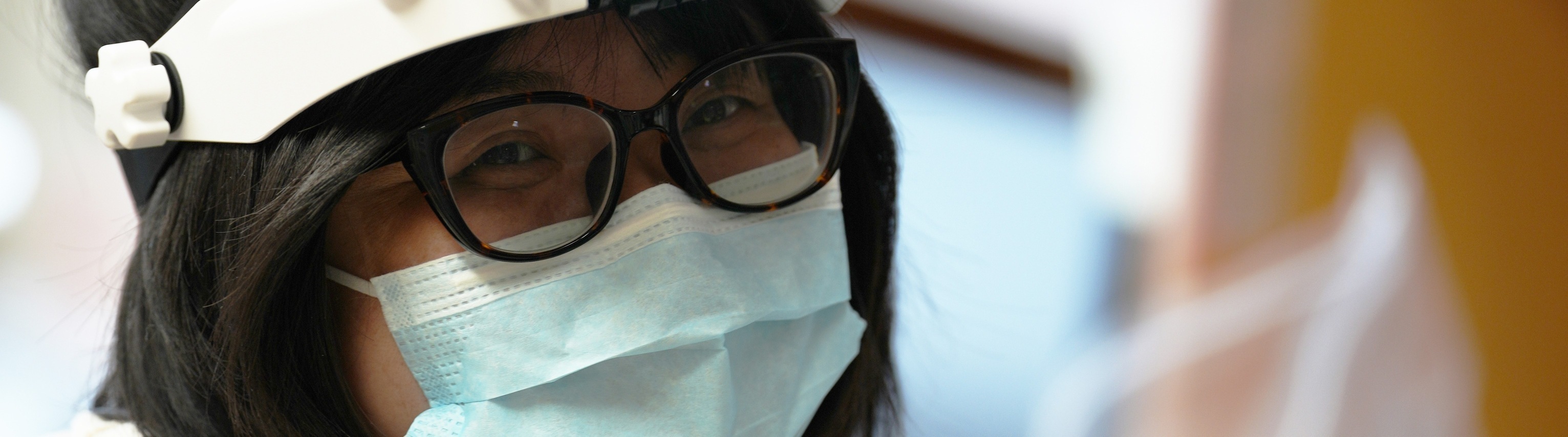 Woman wearing headlamp and mask.