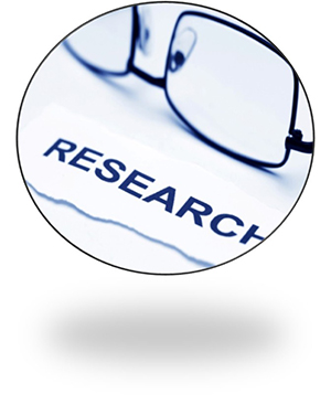 Pair of glasses laying on a surface above a piece of paper with the word research