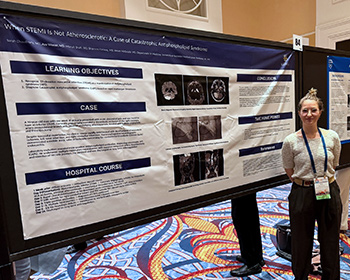 Ava Wexler, MD, posing at one of her posters.