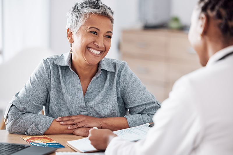 older woman at a table talking with doctor