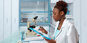 African American woman looking at paperwork while performing research