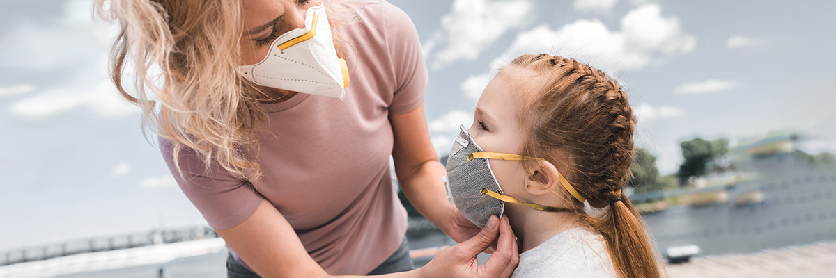Mother and child putting on protective masks