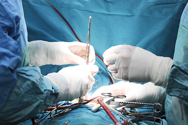 Gloved hands performing a procedure.