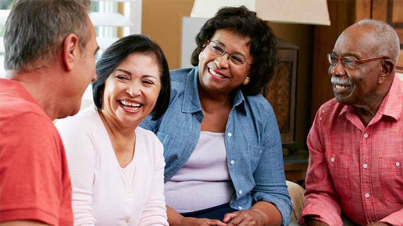 a group of four older adults talking