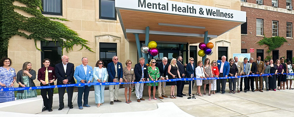 Large Group of people cutting ribbon at opening of buliding