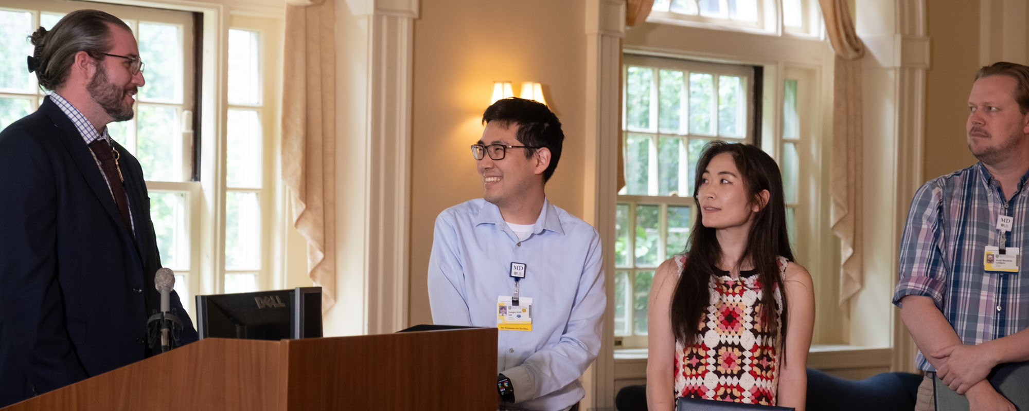 Faculty member presenting awards to 3 residents