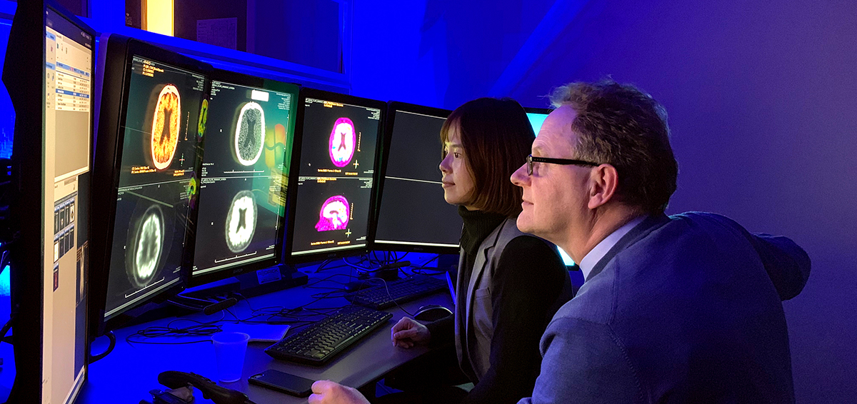 Pair of researchers looking at images on computer screens